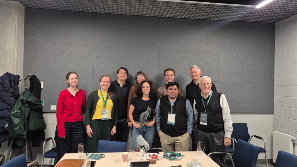 Participants of the workshop with Prof. John “Fritz” Schwaller and Eduardo de la Cruz Cruz, including Gabriela Piszczatowska, Agnieszka Brylak, Julia Madajczak, and Katarzyna Mikulska, pose for a group photo in a conference room.