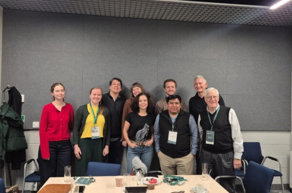 Participants of the workshop with Prof. John “Fritz” Schwaller and Eduardo de la Cruz Cruz, including Gabriela Piszczatowska, Agnieszka Brylak, Julia Madajczak, and Katarzyna Mikulska, pose for a group photo in a conference room.