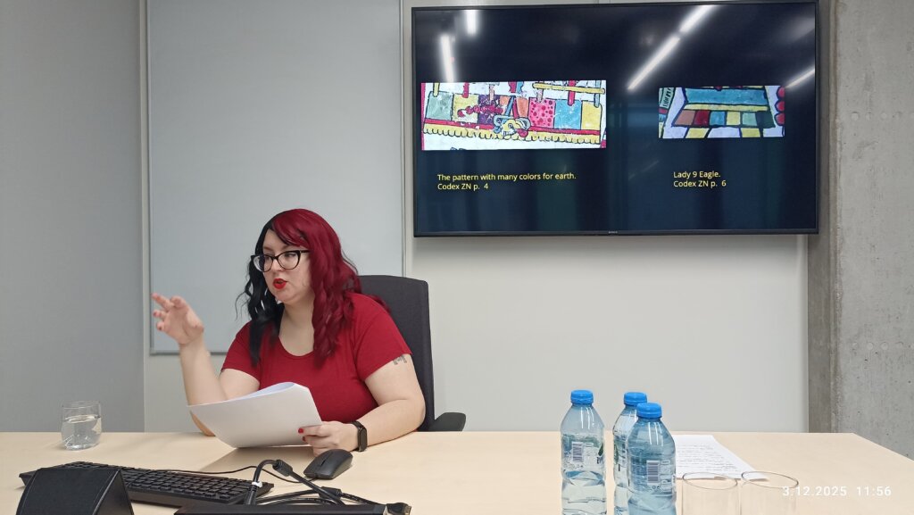 Tonne Teixeira de Andrade Nardi prowadzi prezentację przy stole konferencyjnym, a na ekranie wyświetlają się slajdy zatytułowane „The pattern with many colors for earth. Codex ZN p. 4” oraz „Lady 9 Eagle. Codex ZN p. 6”.