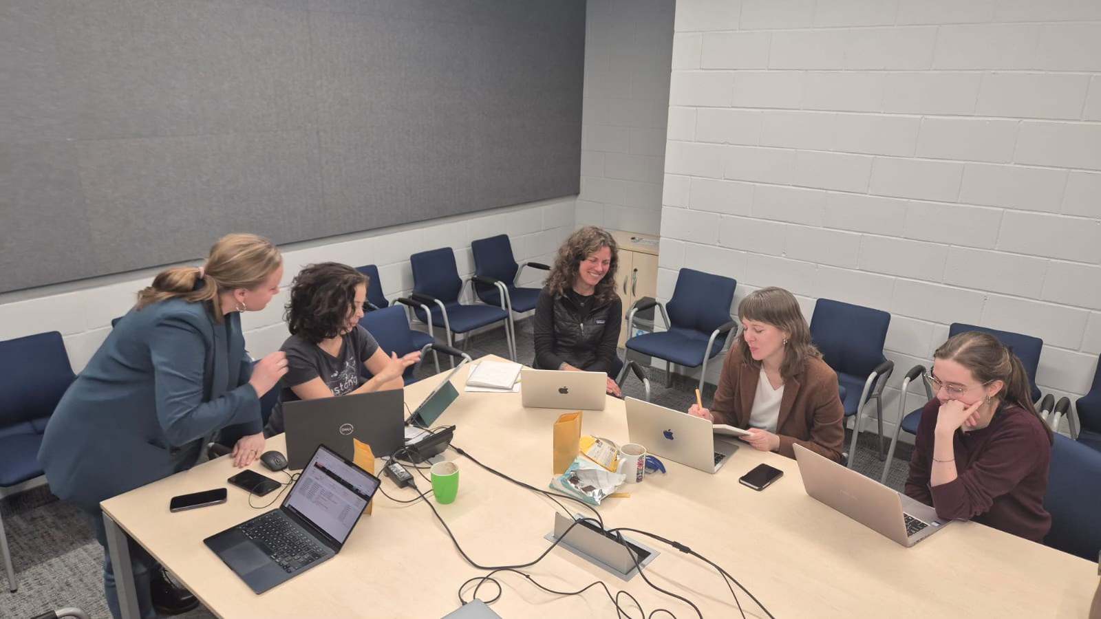 Agnieszka Brylak, Katarzyna Mikulska, Molly Bassett, Julia Madajczak i Gabriela Piszczatowska siedzą przy stole konferencyjnym, pracując na laptopach i prowadząc rozmowę w nowoczesnej sali spotkań.