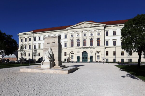 A neoclassical building of the National University of Public Service in Hungary, with a courtyard and a statue on a pedestal.