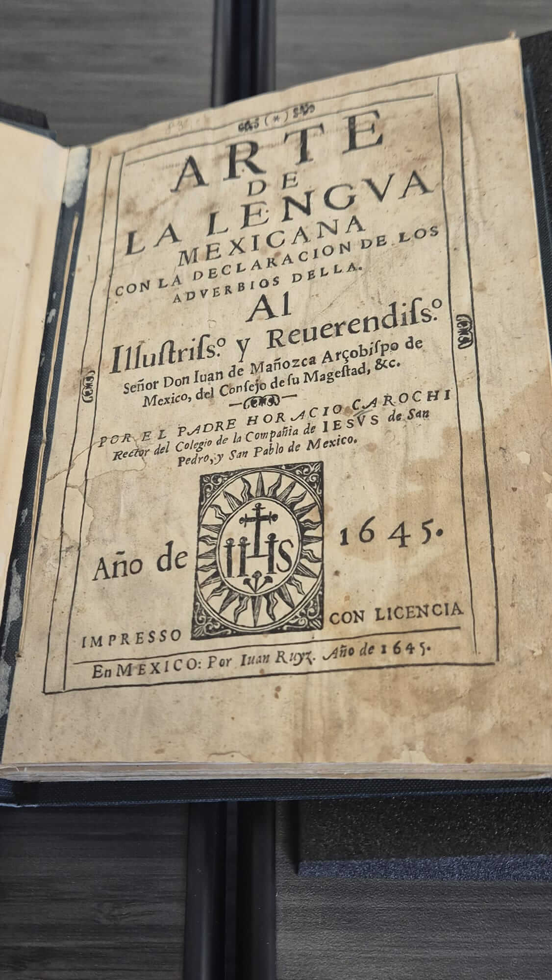 The title page of the 1645 printed book Arte de la lengua mexicana, featuring an aged page and an IHS emblem.